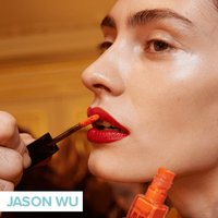person getting red lipstick applied to top lip