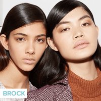 two people wearing neutral makeup and slicked hair