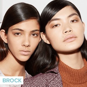 two people wearing neutral makeup and slicked hair