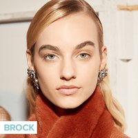 person wearing neutral makeup and slicked hair