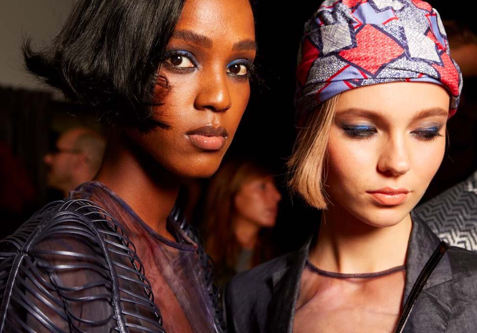 two people wearing blue eyeshadow and clear lip gloss