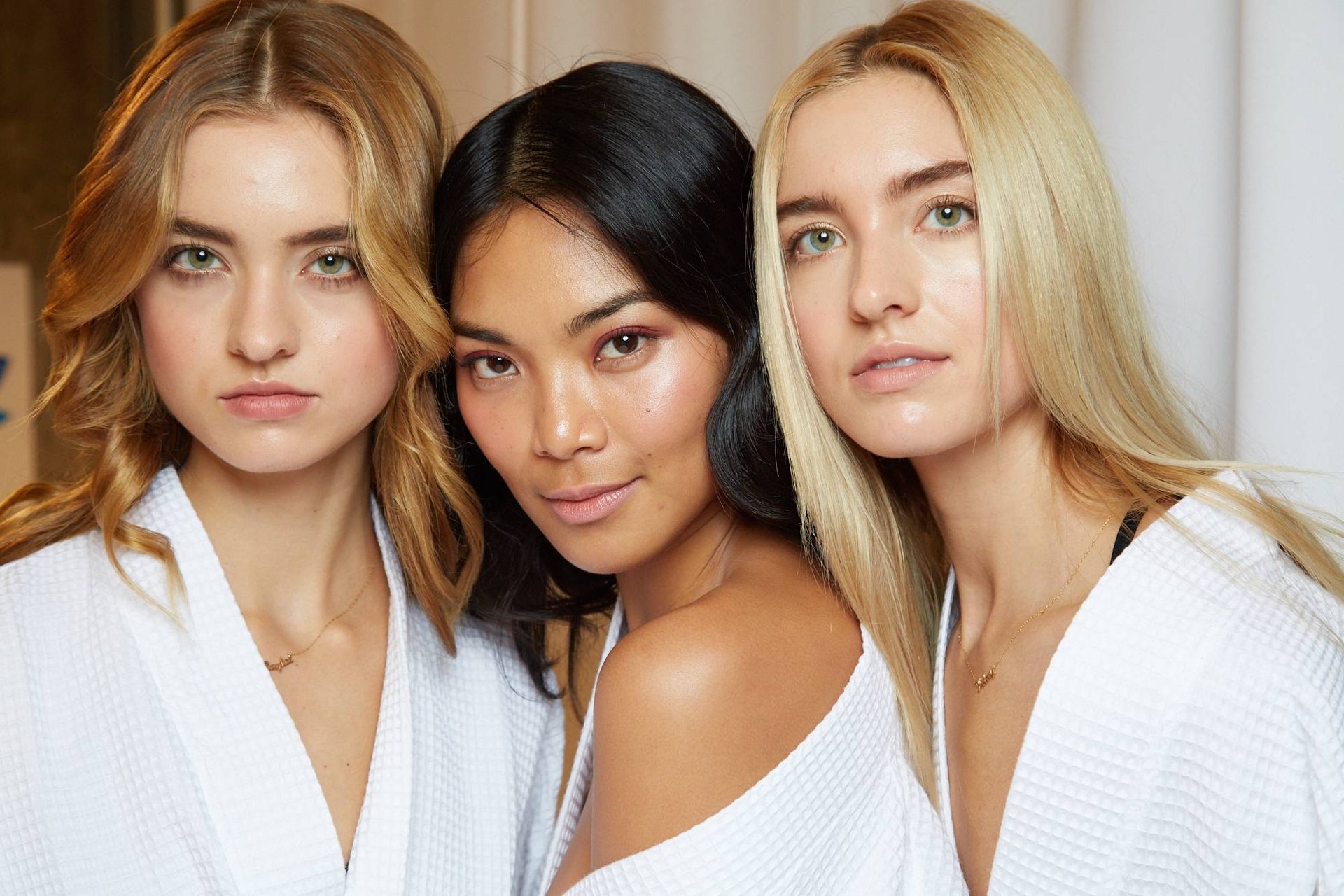 three people wearing natural makeup