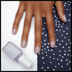 hand with nails painted with art art pose next to bottle of nail polish