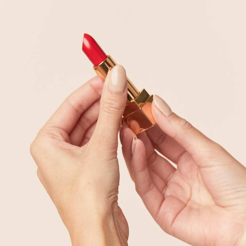 hands holding tube of red lipstick