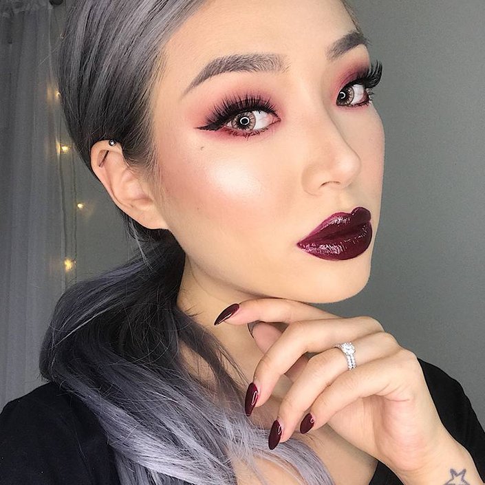 person wearing burgundy eyeshadow, lipstick and nail polish