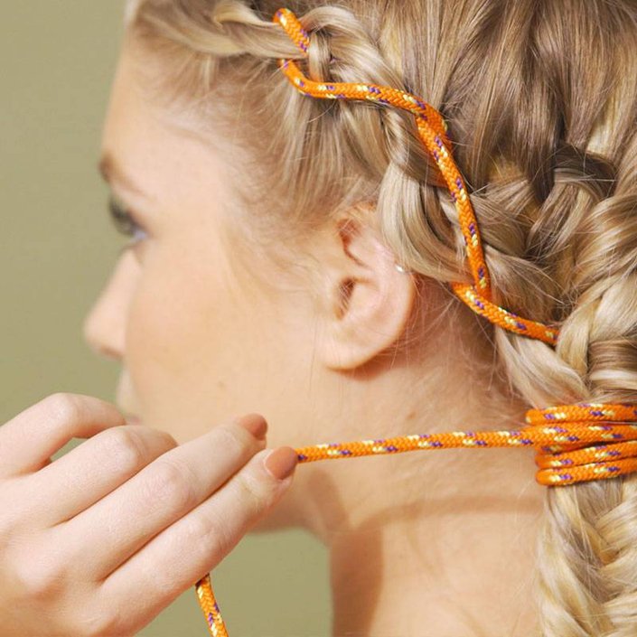 person with orange rope braided into hair