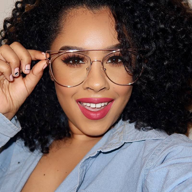 person with naturally curly hair wearing glasses and pink lipstick