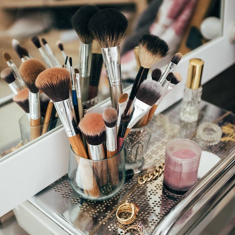 makeup brushes in glass cup