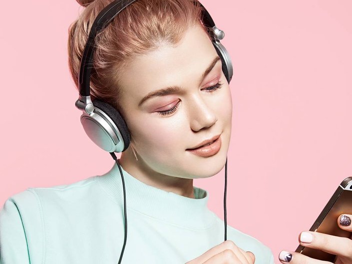 person wearing headphones and looking at iphone