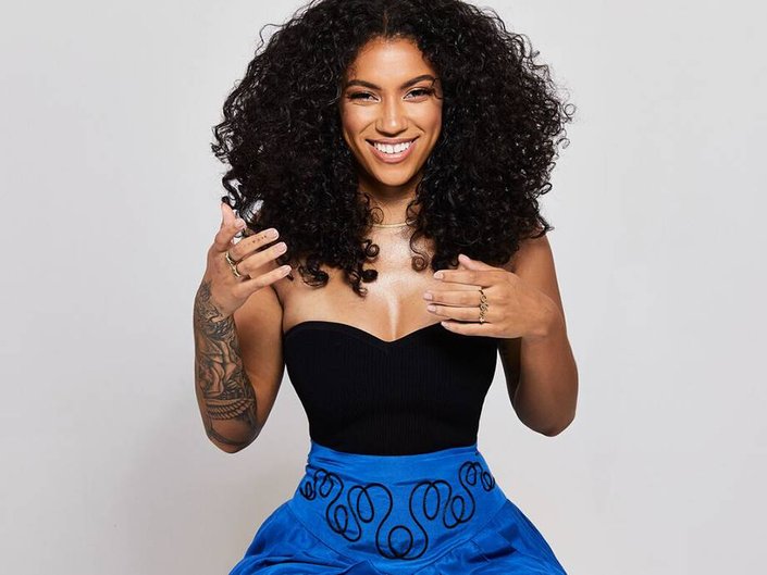 person with naturally curly hair smiling at camera