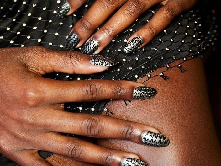 hands with nail art on nails resting on lap