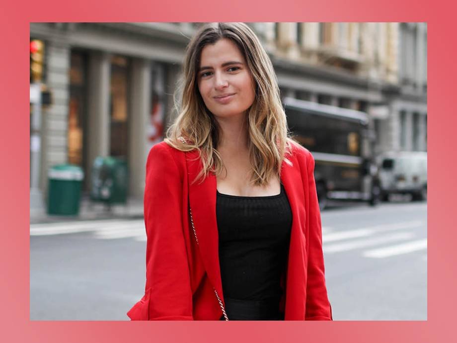 person smiling and wearing black shirt and red jacket