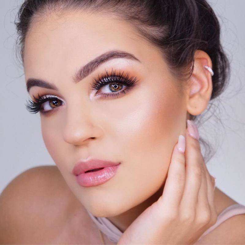 person wearing highlighter on eyes and cheeks and shimmering lip gloss