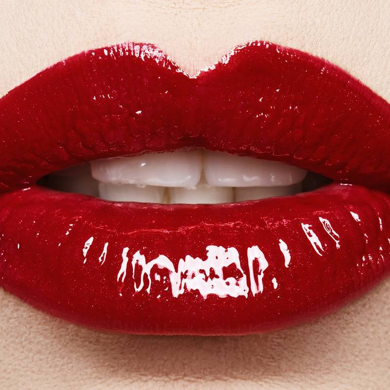 lips wearing glossy red lipstick