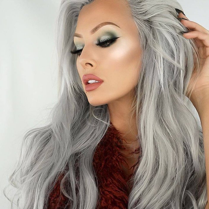 person with long silver hair wearing green smokey eye and nude lipstick
