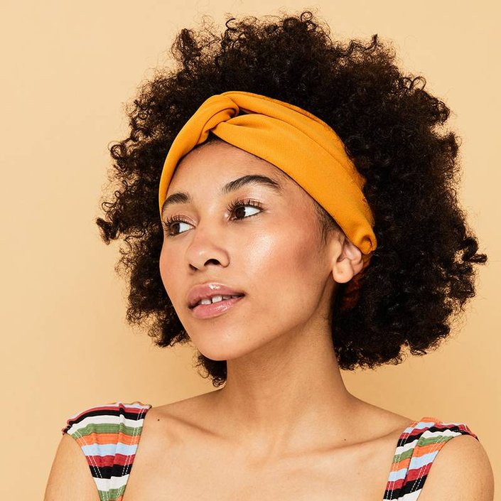 person with naturally curly hair wearing highlighter on cheeks