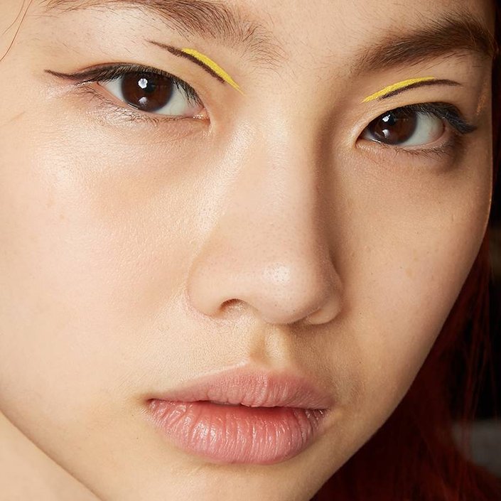 person wearing barely there makeup and graphic eyeliner