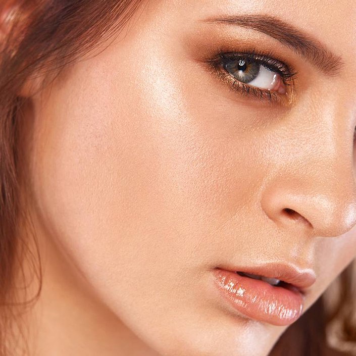 person wearing copper eyeshadow and clear lip gloss