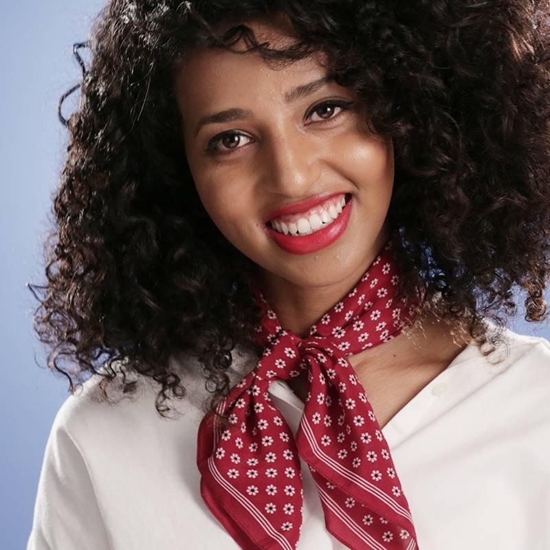 person with naturally curly hair wearing red lipstick