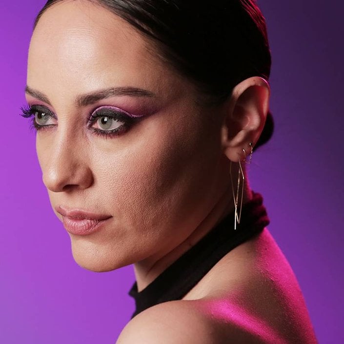 person wearing black eyeshadow and neon eyeliner