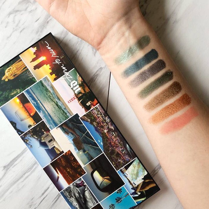 Urban Decay Born To Run Palette next to arm filled with eyeshadow swatches