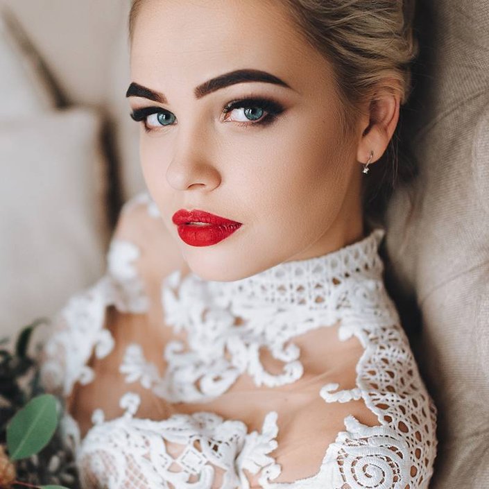 person wearing red lipstick and smokey eyeshadow