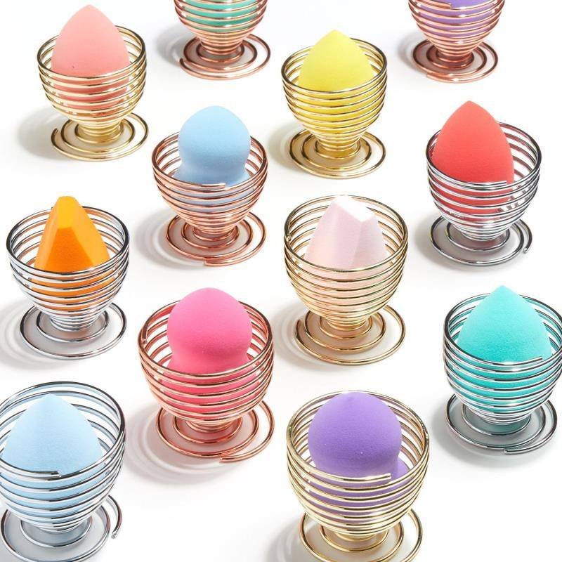 colorful makeup sponges sitting in gold, rose gold, and silver spiral holders
