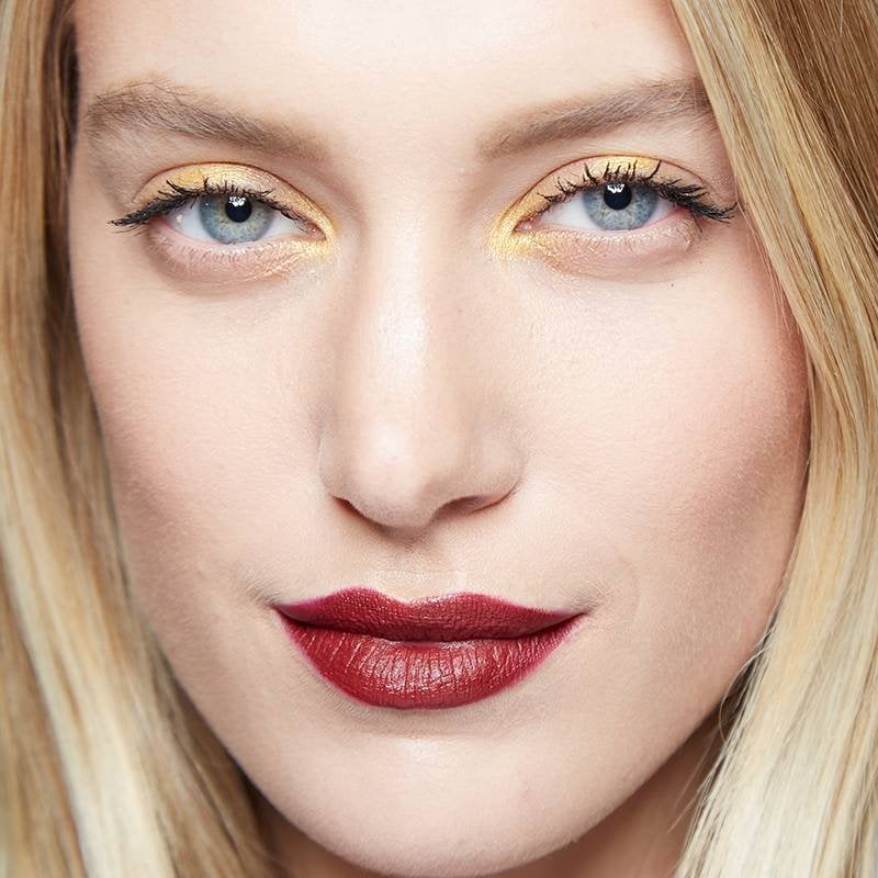 person with blonde hair wearing yellow eyeshadow and red lipstick