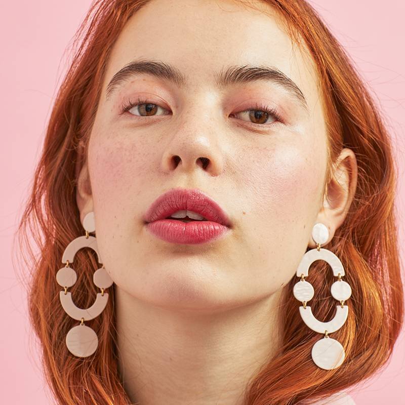 person wearing pale pink makeup and pink lip tint