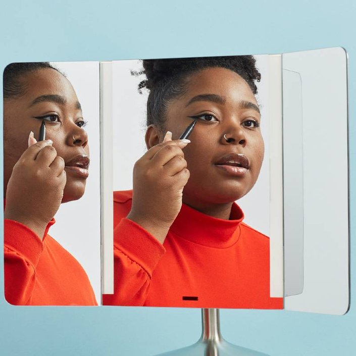 person applying eyeliner in simplehuman mirror