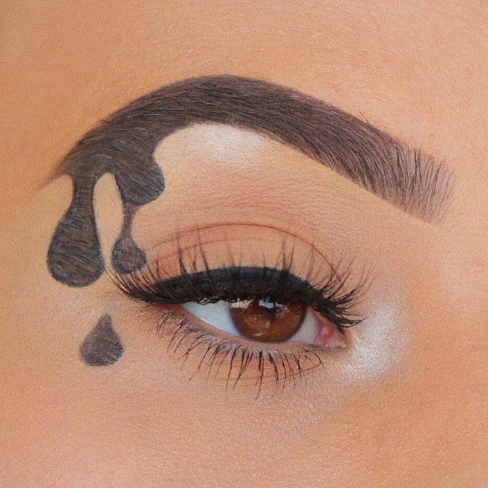 close-up of person's eye wearing dripping eyebrow makeup