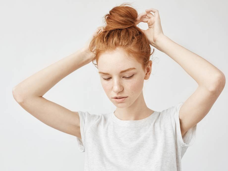 person with red hair wearing a high bun