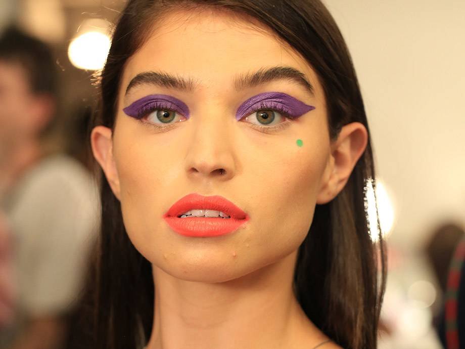 person wearing purple eyeshadow and coral lipstick