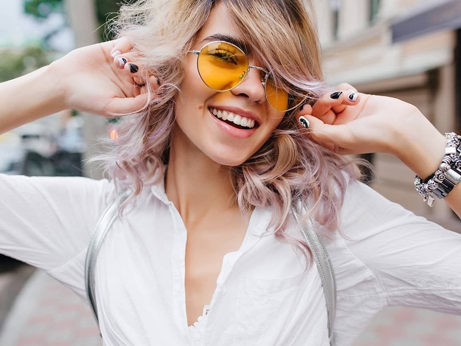 person smiling and wearing yellow lensed sunglasses