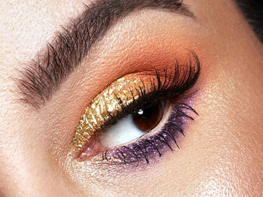 close-up of person's eye wearing gold and purple eyeshadow