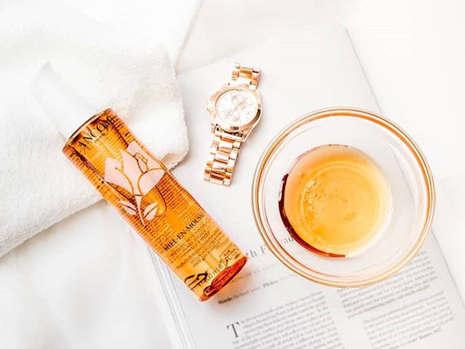 lancome miel-en-mousse cleanser, a gold watch, and honey in a glass cup