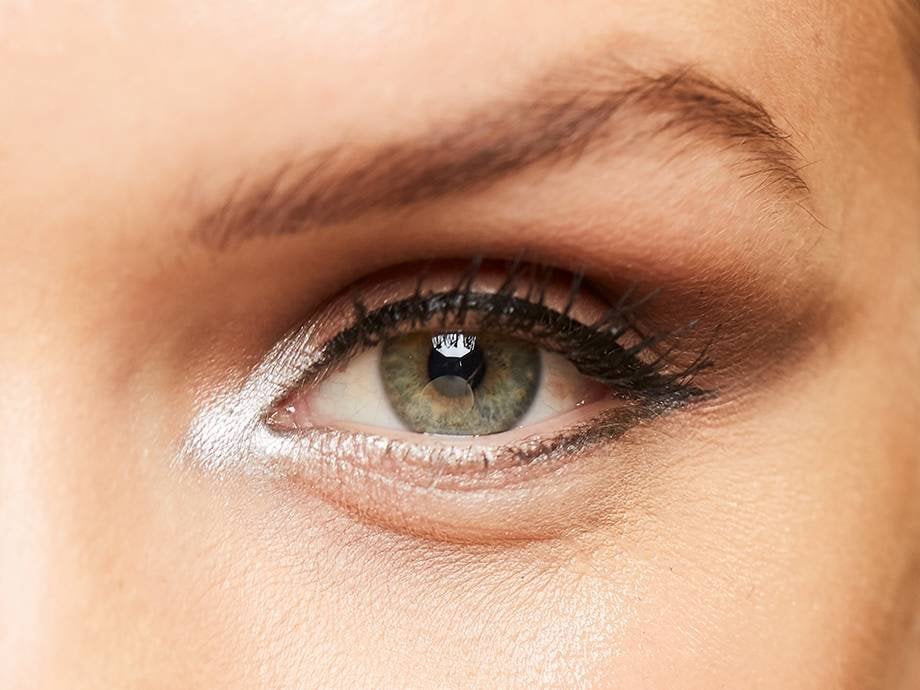 close-up of person's eye wearing black and silver makeup