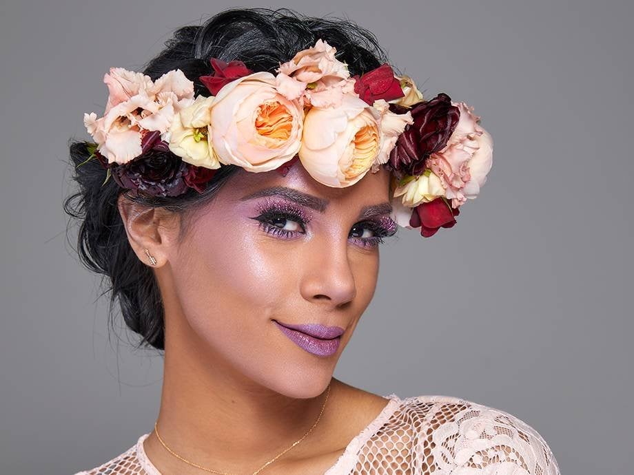 person wearing a flower crown and purple fairy-inspired makeup