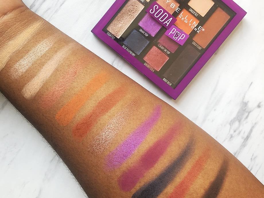 Maybelline Soda Pop Eyeshadow Palette next to arm filled with eyeshadow swatches