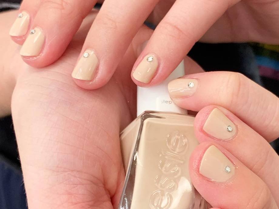 nail with nails painted nude holding essie nude nail polish