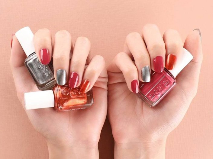 hands holding essie nail polishes