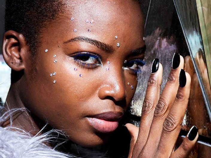 person wearing blue mascara and rhinestones on face