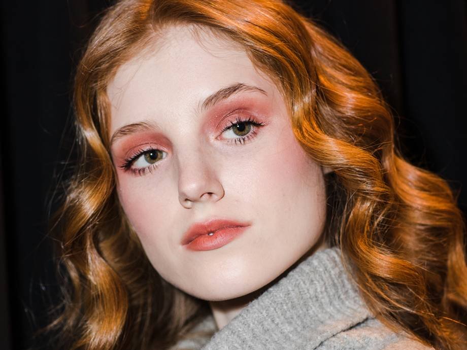 person with red hair wearing red eyeshadow and lipstick