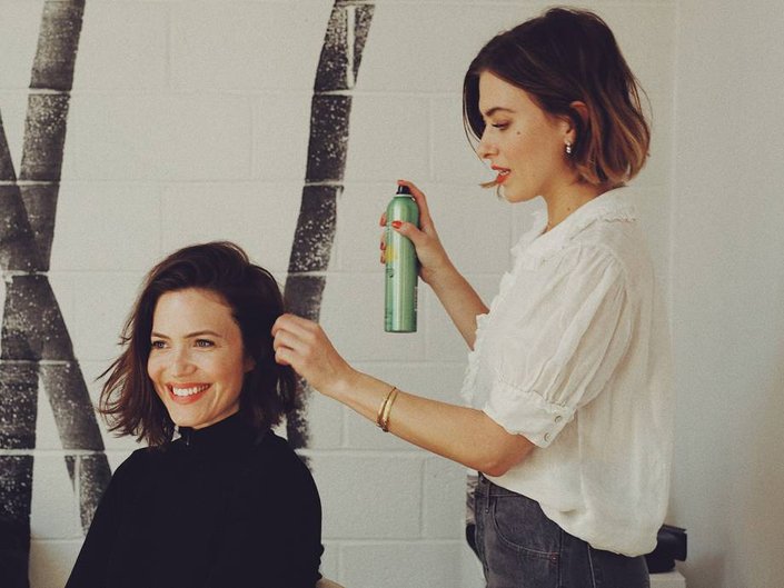 person styling mandy moore's hair