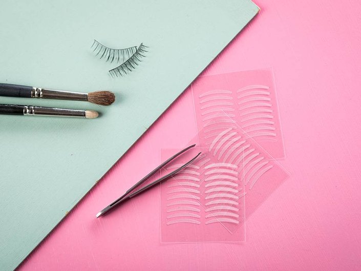 eyeshadow makeup brushes, false eyelash strips, tweezers, and eyebrow stencils