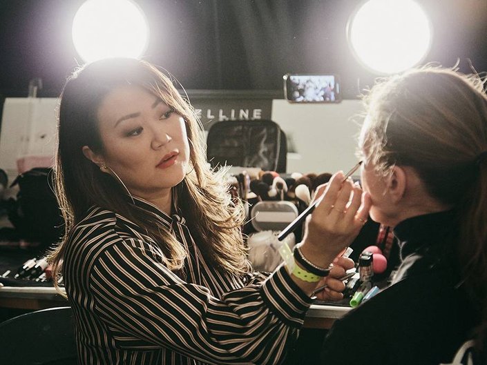 person applying makeup to someone else