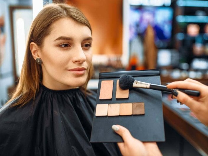 person getting their makeup done at a beauty counter