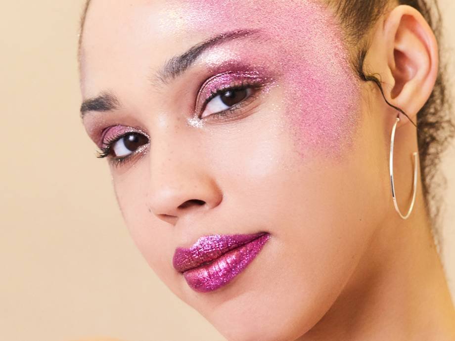 person wearing pink glitter makeup on eyelids, temples, and lips