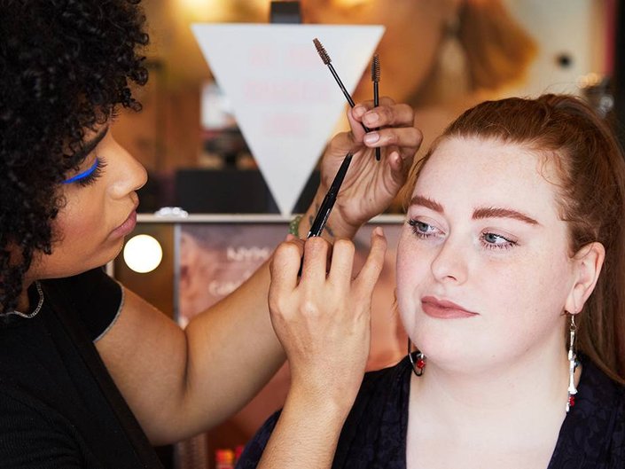 person applying makeup to someone else
