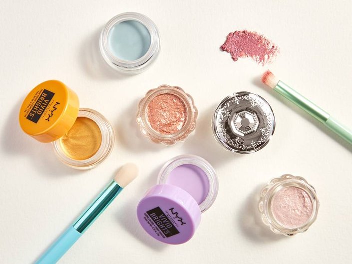 various eyeshadow pots and two eyeshadow brushes